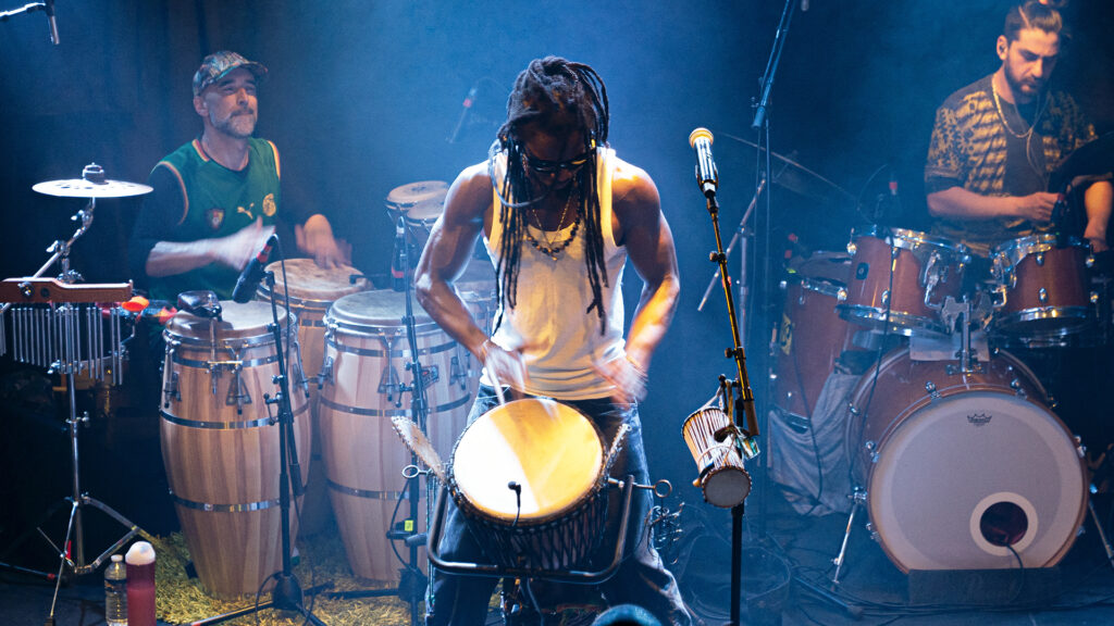 Le chanteur Balla Bangoura du groupe Terya Silo en train de jouer du djembé lors d'un live filmé par la Mine Productions